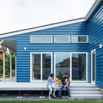 外壁は鮮やかなブルーのガルバリウム鋼板。リビングの前は日当たりのいいテラスで、気軽にアウトドアを楽しめる。
